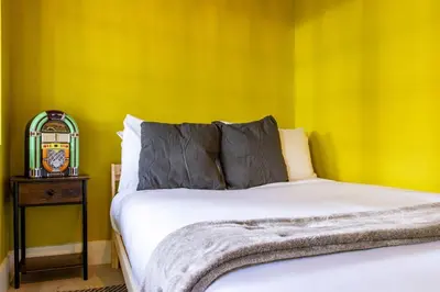 a bedroom with a bed and a clock on a table at Casa Fillmore - Hollywood Oasis in Hollywood