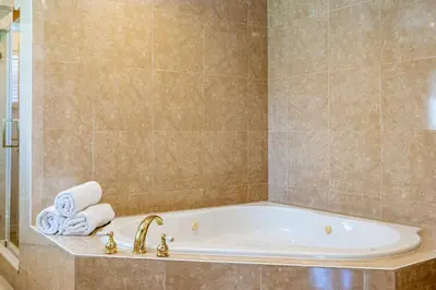 a bathroom with a tub with towels and a shower at Villa Tation 8BR Mini Hotel in Plantation