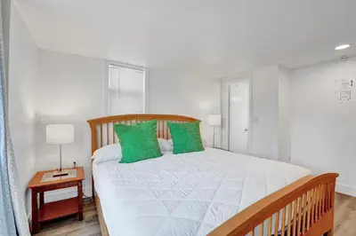 a bedroom with a large bed with green pillows at Seaside Beach House in Hollywood