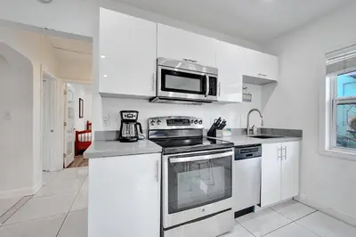 a kitchen with white cabinets and a microwave at Seaside Beach House in Hollywood