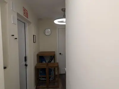 a hallway with a clock on the wall and a door at Beach Breeze Suite - Steps to the Beach in Hollywood