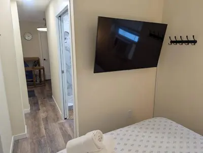 a bedroom with a flat screen tv on the wall at Beach Breeze Suite - Steps to the Beach in Hollywood
