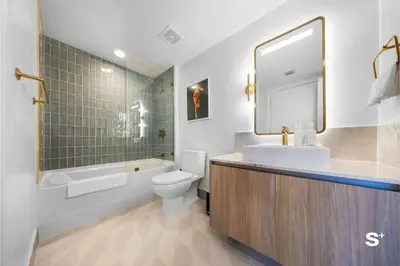 a bathroom with a sink and a toilet and a mirror at Stylish 1-BD Condo - City Views in Miami