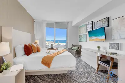 a bedroom with a bed and a desk and a window at 2 BR Apartment with Amenities and Balcony in Hollywood