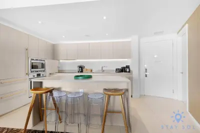 a kitchen with three bar stools and a counter at 2 BR Apartment with Amenities and Balcony in Hollywood