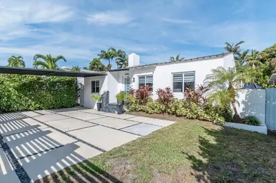 a white house with palm trees and a fence at Casa Belle 3br W Pool & Bbq 10 Mins To Beach in Miami