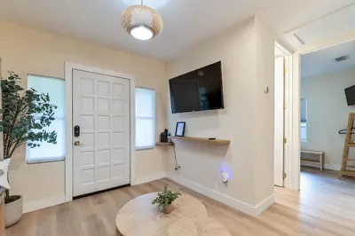 a living room with a white door and a table at Casa Bellini Modern 3br W Bbq -10 Mins To Beac in Miami