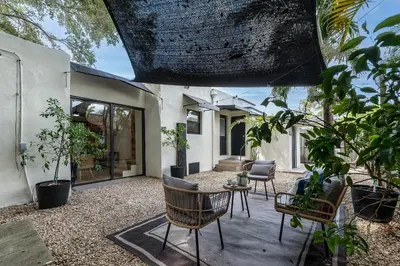 a patio with chairs and a table and some plants at Casa Bellini Modern 3br W Bbq -10 Mins To Beac in Miami