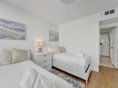 a white bedroom with two beds and a dresser at Lovely 2BR condo with Resort Access, Gym and Pool 1608 in Miami Beach