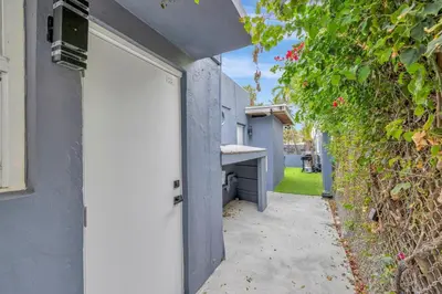 a white door on a building with a hedge at Banyan St 2BR 1BA off Las Olas- Steps to Beach unit 4 in Fort Lauderdale