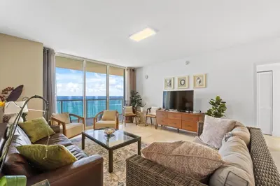 a living room with a couch and a table at Luxurious 2BD Condo with Direct Ocean Front & Resort Pool in Sunny Isles in Sunny Isles Beach