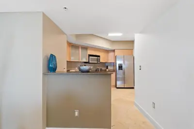 a kitchen with a counter and a refrigerator at Luxurious 2BD Condo with Direct Ocean Front & Resort Pool in Sunny Isles in Sunny Isles Beach