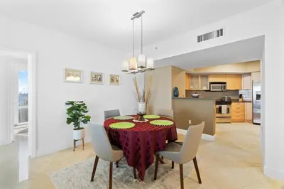 a kitchen and dining room with a table and chairs at Luxurious 2BD Condo with Direct Ocean Front & Resort Pool in Sunny Isles in Sunny Isles Beach