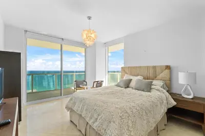 a bedroom with a bed and a large window at Luxurious 2BD Condo with Direct Ocean Front & Resort Pool in Sunny Isles in Sunny Isles Beach
