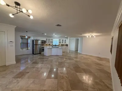 an empty living room with a kitchen and a large room at 1644 Jackson St, Hollywood, FL 33020 in Hollywood