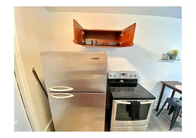 a kitchen with a stainless steel refrigerator and a stove at Cozy Place Near Design District - 2 in Miami