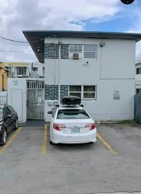 a white car parked in a parking lot in front of a building at Cozy Place Near Design District - 2 in Miami