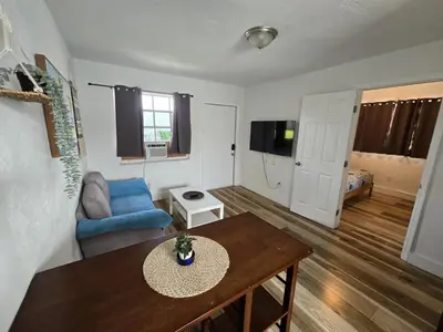 a living room with a table and a blue couch at Cozy Place Near Design District - 4 in Miami