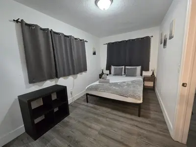 a bedroom with a bed with black curtains at Cozy Place Near Design District - 3 in Miami