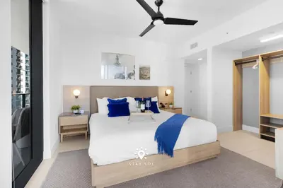 a bedroom with a large bed with blue pillows at Modern Stylish Apt 2BR-2BTH in Miami