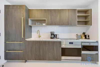 a kitchen with wooden cabinets and a sink at 1 BR - City Views Gym & Pool in Miami