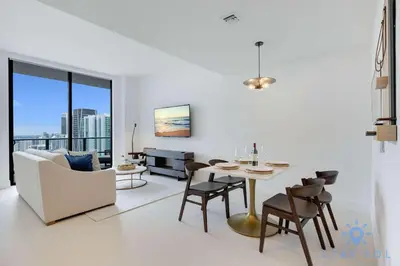 a white living room with a table and chairs at Best Stay - City Views Gym & Pool in Miami