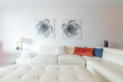 a white couch in a living room with two pictures on the wall at Ocean Reserve in South Island
