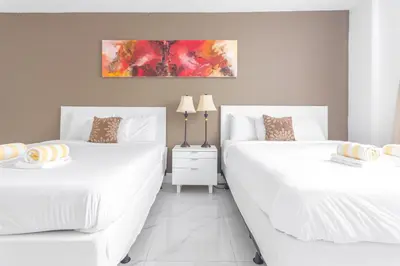 two white beds in a room with white floors at Ocean Reserve in South Island