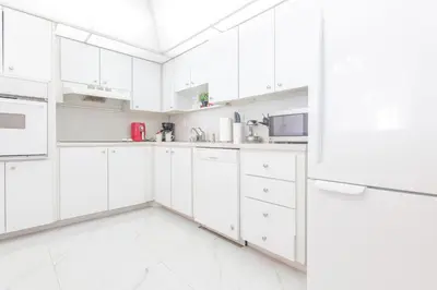 a white kitchen with white cabinets and appliances at Ocean Reserve in South Island