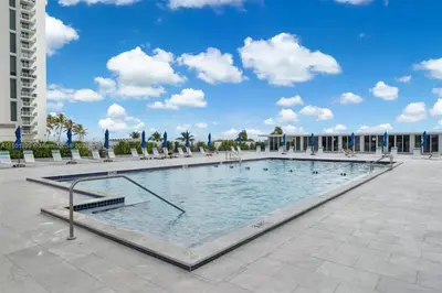 a large swimming pool in the middle of a courtyard at Miami apartamento sobre la playa con estacionamiento gratuito in Miami Beach