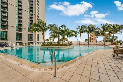 a swimming pool with palm trees and a building at Lemon Drop - Modern Central & Full Amenities in Miami