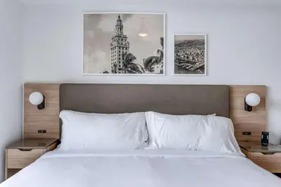 a bedroom with a bed with two pictures on the wall at Lemon Drop - Modern Central & Full Amenities in Miami
