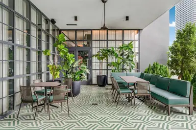 an outdoor patio with tables and chairs and plants at Lemon Drop - Modern Central & Full Amenities in Miami