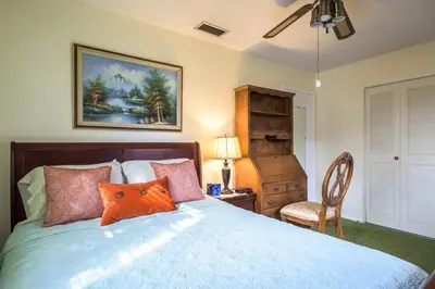 a bedroom with a bed with an orange pillow on it at Oasis1080 Resort in Plantation