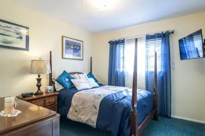 a bedroom with a bed with blue sheets and blue curtains at Oasis1080 Resort in Plantation