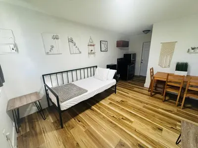 a living room with a bed and a table at Cozy place Near Design District - 1 in Miami