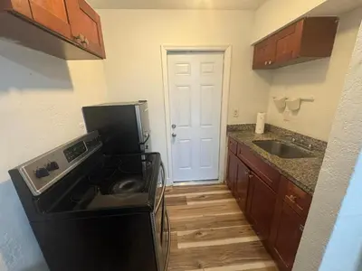a kitchen with a black refrigerator and a sink at Cozy place Near Design District - 1 in Miami