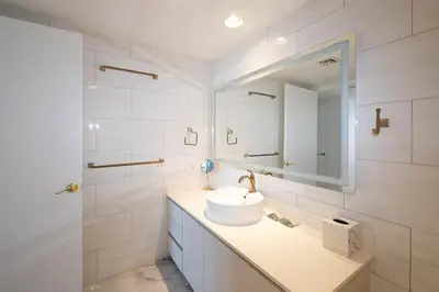 a white bathroom with a sink and a mirror at The Royal Suite of Beachwalk 2b 2b Apmt in Hallandale Beach