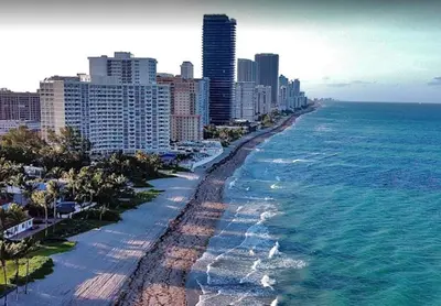 an aerial view of a beach with buildings and the ocean at The Royal Studio of Beachwalk in Hallandale Beach