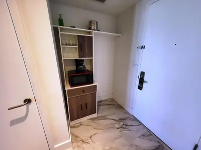 a small room with a microwave and a door at The Royal Studio of Beachwalk in Hallandale Beach