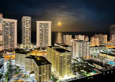 a view of a city at night with tall buildings at The Royal Studio of Beachwalk in Hallandale Beach