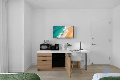 a room with a desk with a computer on the wall at Unique 2BR Apartment Gym & Pool in Hallandale Beach
