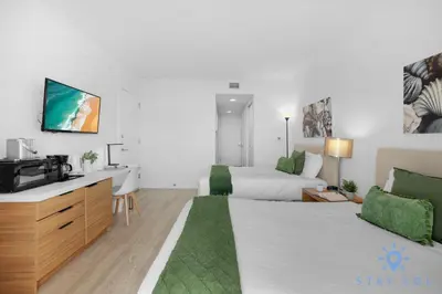 a hotel room with a bed and a tv at Unique 2BR Apartment Gym & Pool in Hallandale Beach