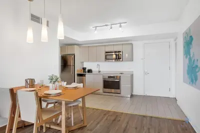 a kitchen and dining room with a wooden table at 1BR Apartment with Balcony-Near Beach in Hallandale Beach