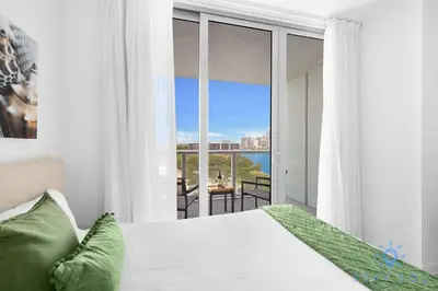 a bedroom with a bed and a view of the ocean at Studio Miami Views - Amenities in Hallandale Beach