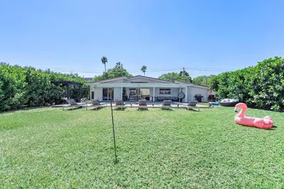 a backyard with a fake pink flamingo in the grass at The Miami Enchanted Lake House in Ojus