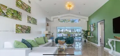 a living room with a white couch and green walls at The Miami Enchanted Lake House in Ojus
