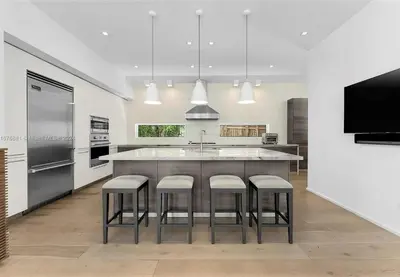 a kitchen with a large island with stools around it at Villa Tranquil Luxe Modern Oasis with Private Pool in Miami Beach in Miami Beach