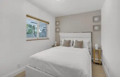 a white bedroom with a white bed and a window at Opulent Home with Sauna & Pool in Hollywood