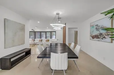 a dining room with a table and white chairs at Opulent Home with Sauna & Pool in Hollywood